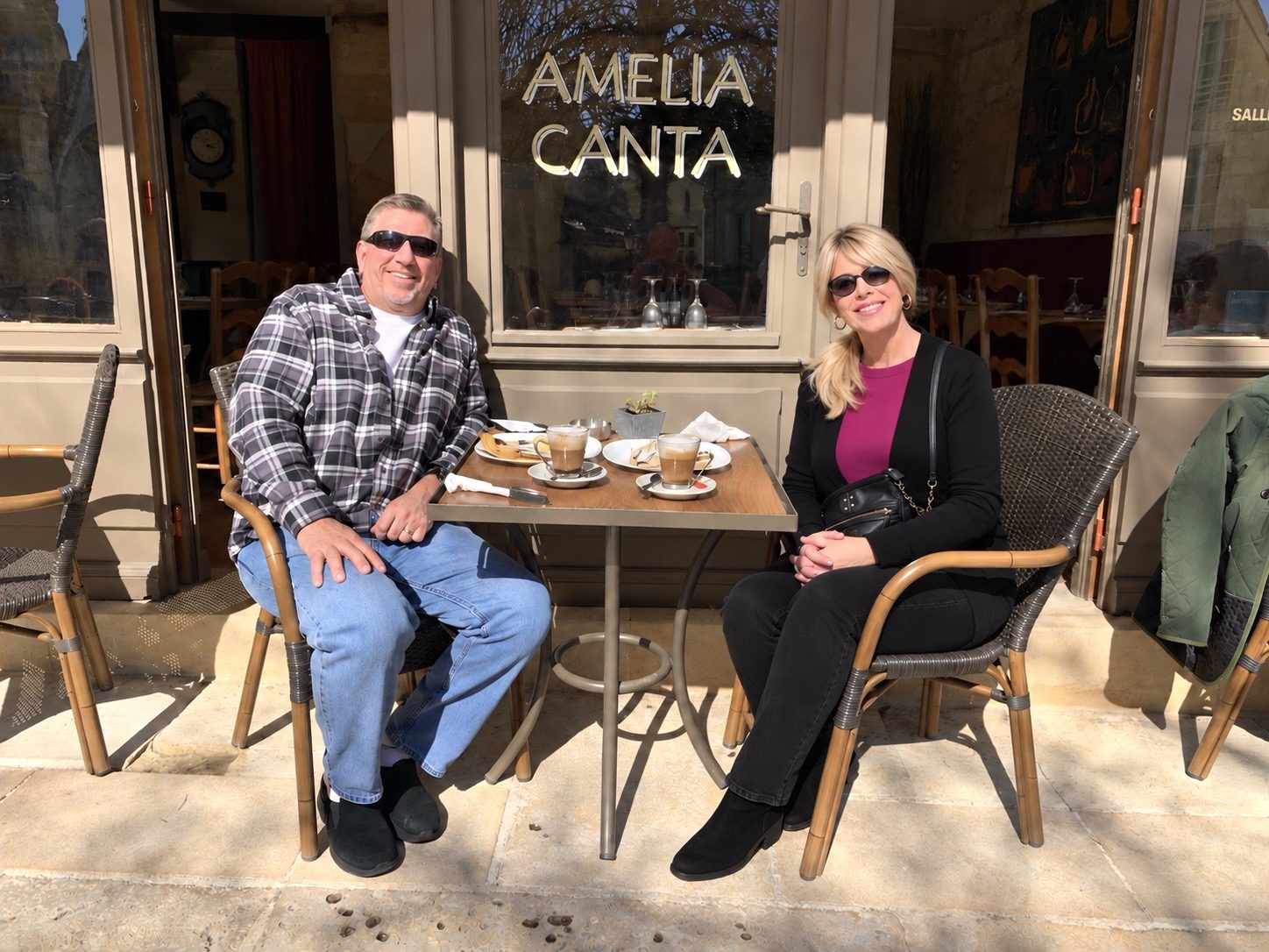 Laura North and her husband at an outdoor café table in front of Amelia Canta in Saint-Émilion.