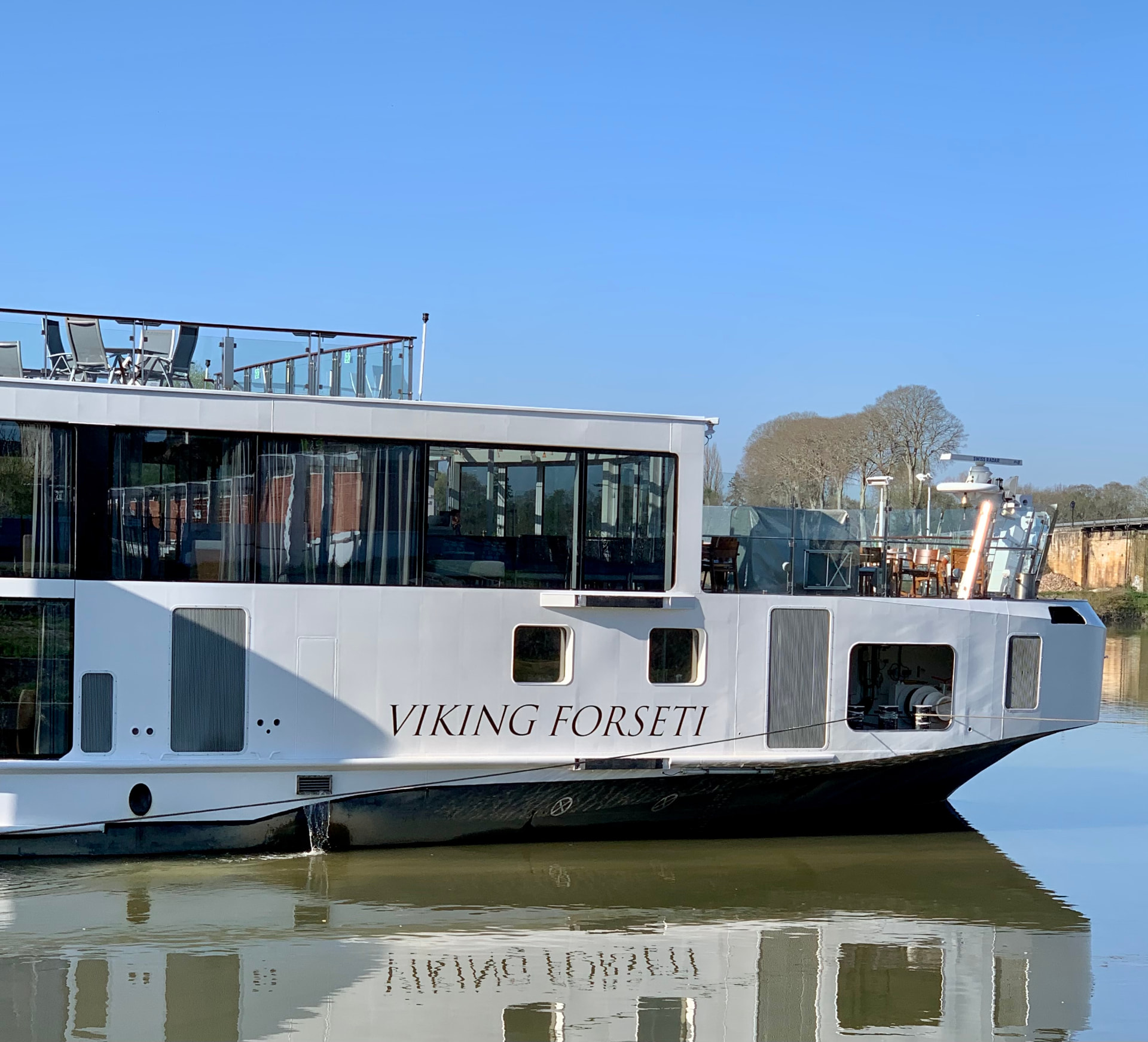 The Viking Forseti river cruise ship docked on a calm river.